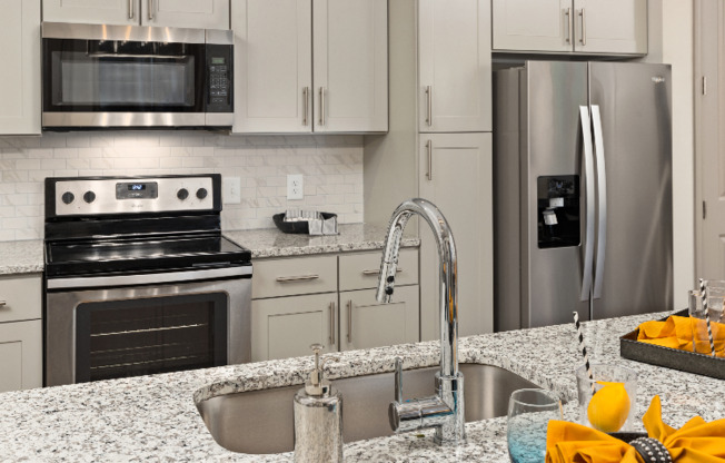 Model kitchen at our apartments in Atlanta, GA, featuring granite countertops and stainless steel appliances.