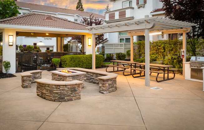 A patio with a fire pit and seating area.