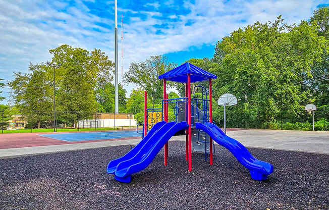 a playground with a blue slide and a red