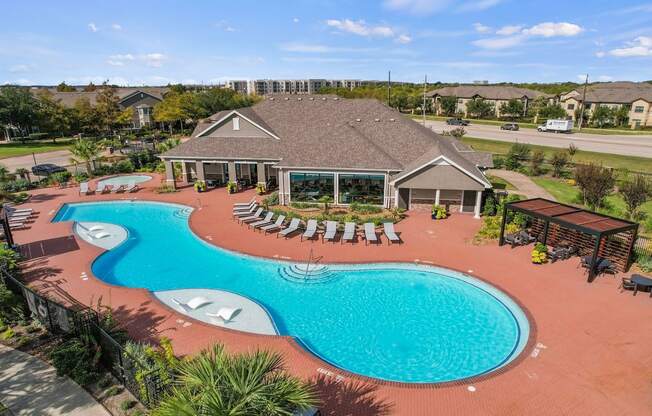 an aerial view of a swimming pool and a house with a resort style pool at Sladestone Shadow Creek, Texas