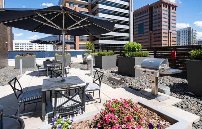 A patio with a table, chairs, and umbrella.