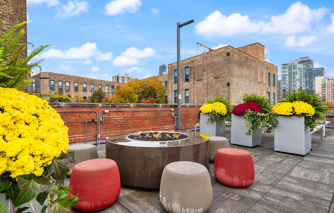 a fire pit on the roof of a building with colorful flowers