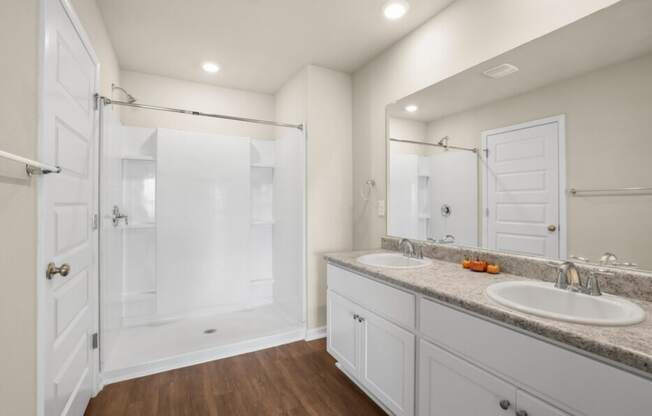 a white bathroom with two sinks and a shower