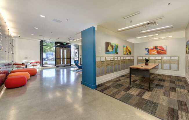 Building Entryway with Mail Room, Geometric Abstract Paintings on Wall, and Red/Orange Seating