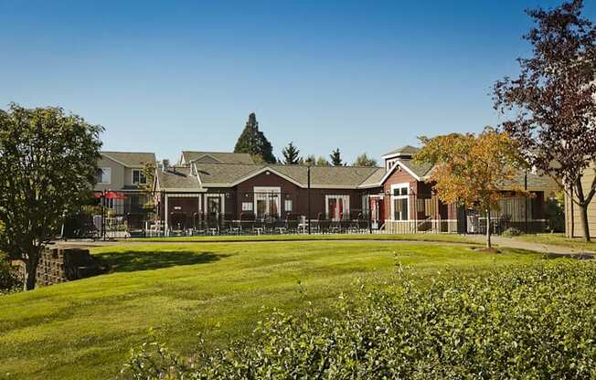 a group of houses on a lawn with a grassy field