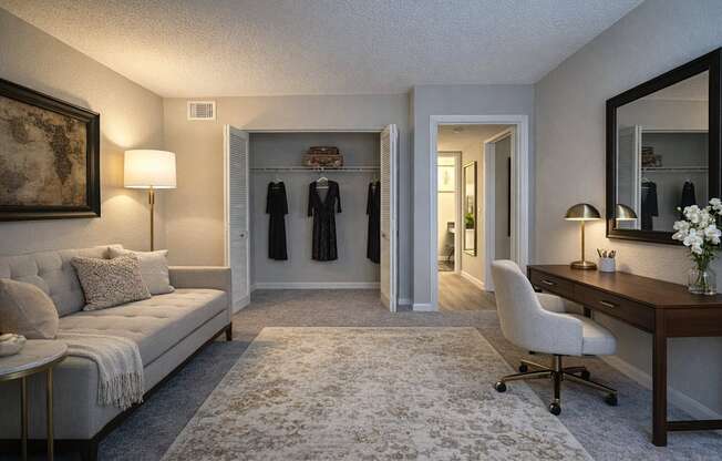 A well-lit room with a couch, desk, and a mirror.