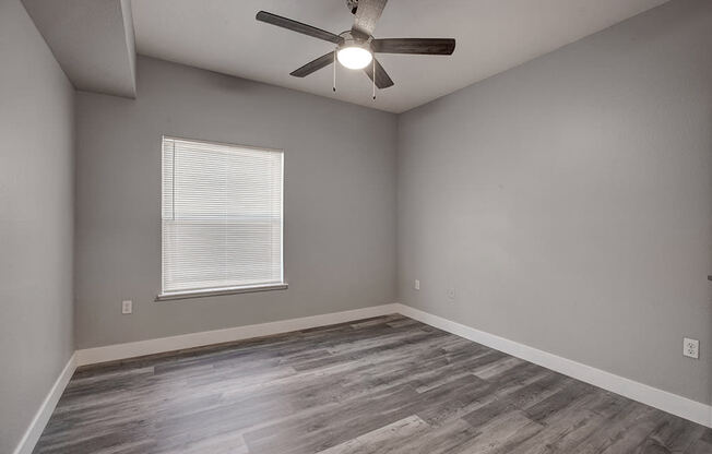 a bedroom with hardwood floors and a ceiling fan