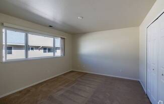 an empty living room with a large window and a door