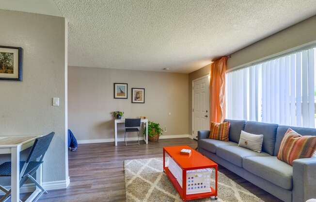 Beige and Grey Walls, Plank Flooring, Large Window, and Popcorn Ceiling at Las Brisas Apartments, Colton