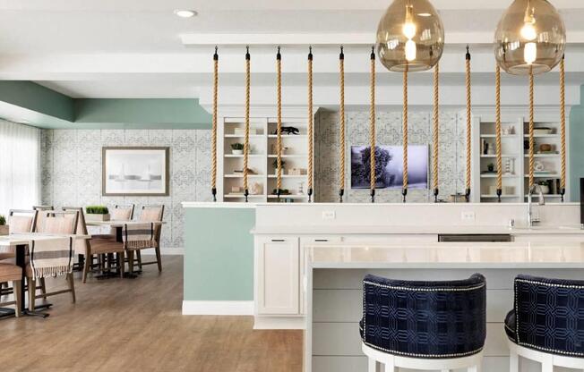 A kitchen with a white counter and blue chairs.