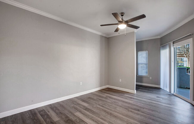 a living room with a ceiling fan and a sliding glass door