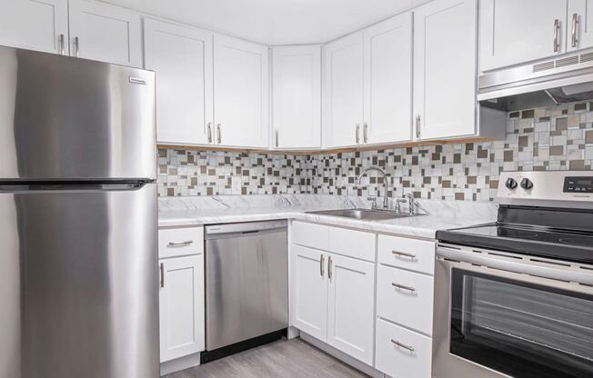 a kitchen with stainless steel appliances and white cabinets