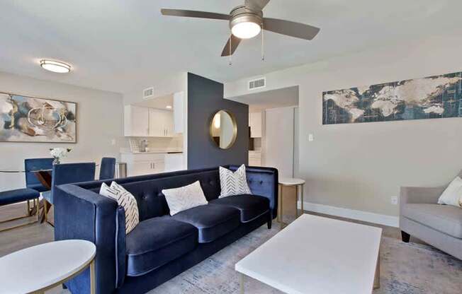 A living room with a blue couch and a white coffee table.