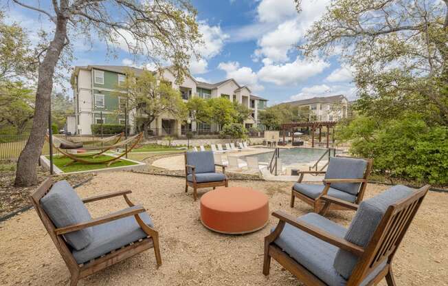 a patio with chairs and a pool and buildings