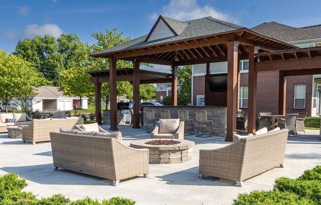 a patio with couches and a pavilion with a fire pit