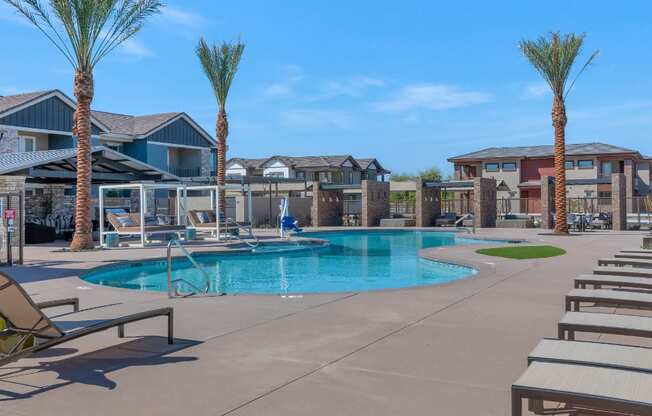 A pool surrounded by palm trees and sun loungers.