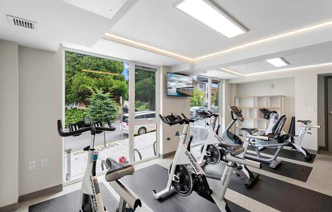 Well-Equipped Fitness Center with Exercise Equipment and Large Windows at Arabella Apartment Homes, Washington