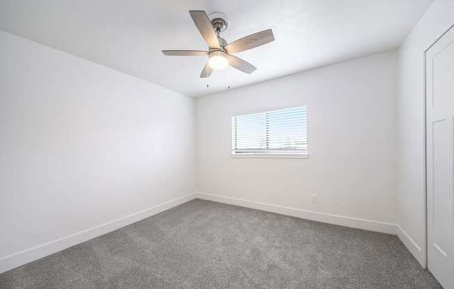 a bedroom with a ceiling fan and a window