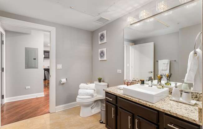 a bathroom with a sink and a toilet and a mirror