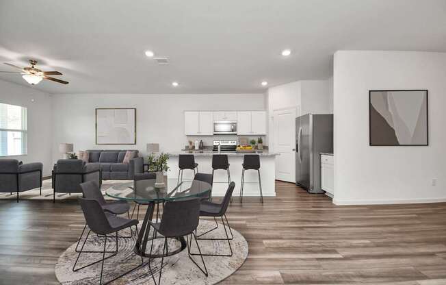 A modern kitchen with a dining table set in the middle of the room.