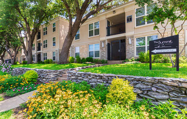 Building exterior and sign directing to the leasing office at The Summit at Midtown Apartments in Midtown, Dallas, TX.