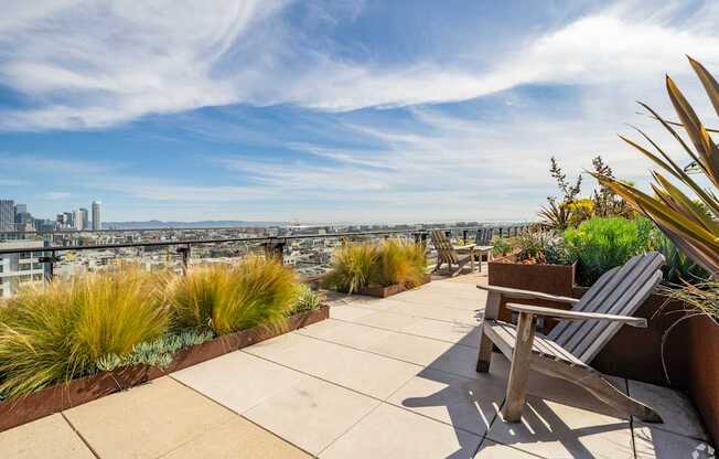 A rooftop patio with a chair and a view of the city.