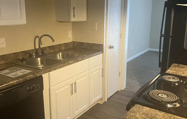 a kitchen with white cabinets and granite counter tops