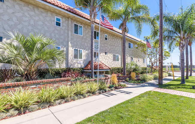 a building with an flag and palm trees in front of it