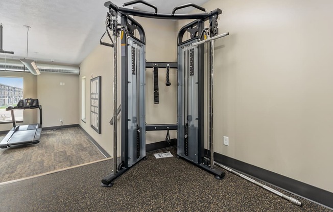 A gym with a treadmill, a weight machine and a treadmill.