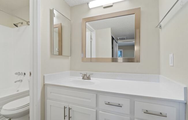 Bathroom with a sink and a mirror and a toilet at Agave Apartments, Tucson