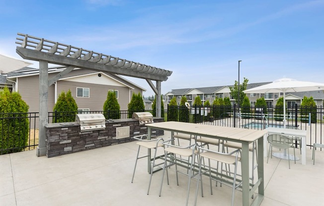 A patio with a table and chairs and a pergola.
