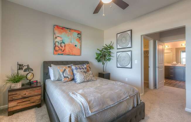 bedroom with ceiling fan and hallway to the bathroom