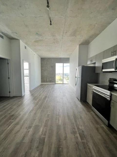 an empty room with a refrigerator and a stove in it