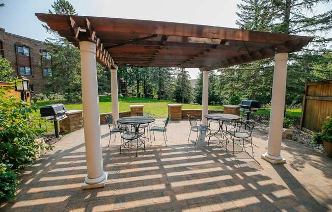 a covered patio with tables and chairs and a pergola