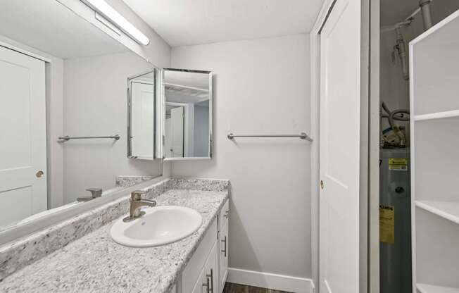 Model bathroom with a marble countertop and a white sink.