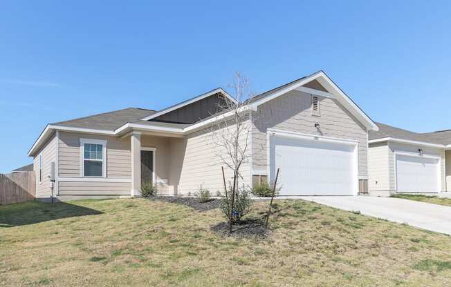 Side view of Dogwood one-story single-family rental house with a fenced-in yard at Beacon at Presidential Heights in Manor, TX