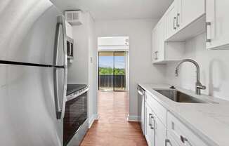 A kitchen with white cabinets and a stainless steel refrigerator at Riverside Apartments, Alexandria, Virginia