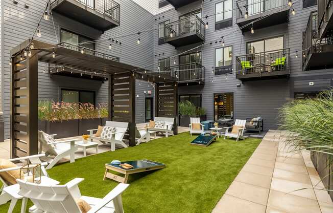 a courtyard with chairs and tables and grass