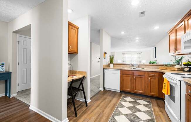 A kitchen with white appliances and wooden cabinets.