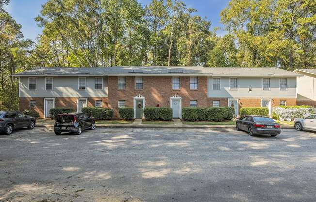 a brick apartment building with cars parked in front of it