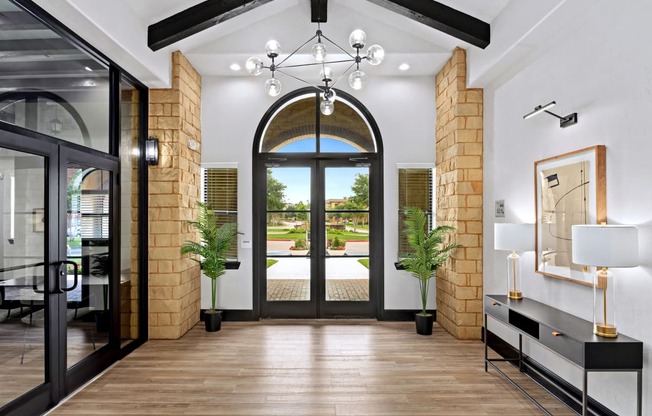 a lobby with a large glass door and a chandelier