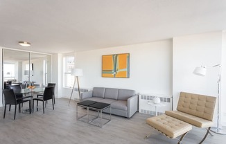 a living room with a gray couch and a yellow painting on the wall