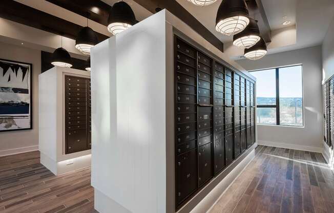 A modern room with a white column and a row of black lockers.