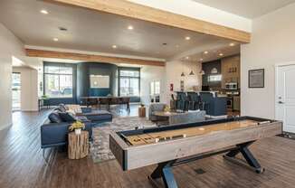 an open living room with a pool table and a kitchen with a bar