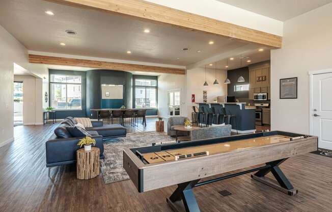 an open living room with a pool table and a kitchen with a bar