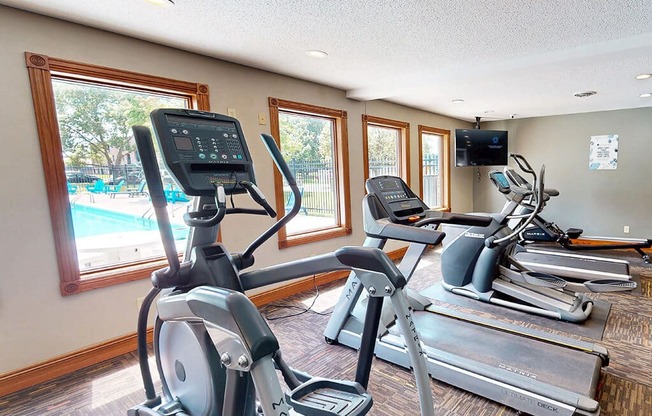 A gym with treadmills and elliptical machines.