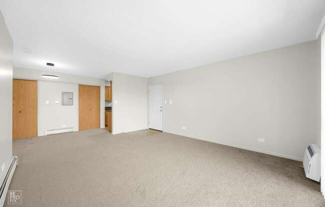 an empty living room with white walls and carpet