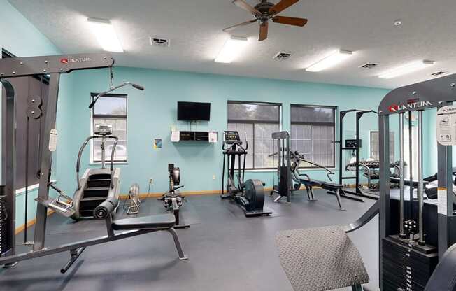 24 hour fitness center with exercise equipment and a flat screen tv