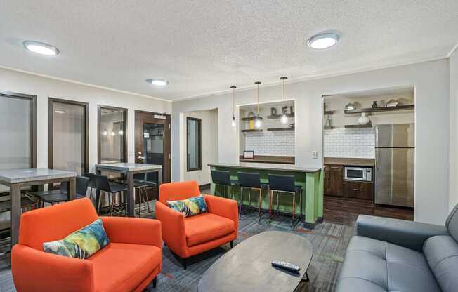 a living room with couches and chairs and a kitchen