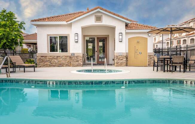 A pool in front of a house with a yellow door.